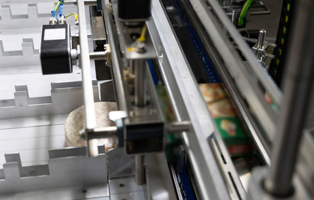 Feeding frozen pizzas in boxes to the HC-S packaging machine from miropack